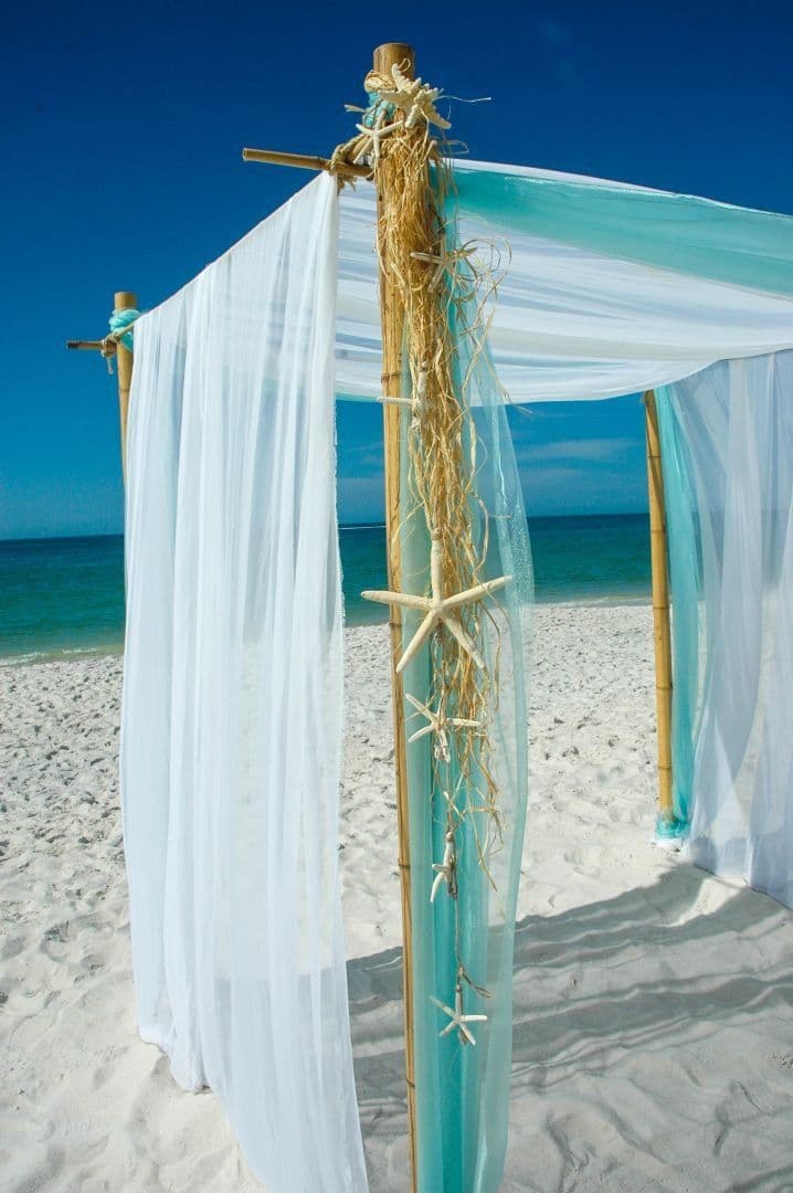 Four-post bamboo canopy detail with aqua and white fabric draping