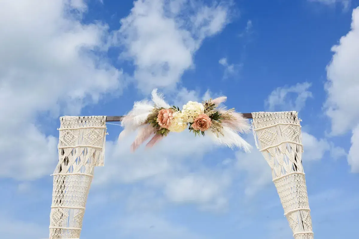 Couple at bamboo arch ceremony with tropical floral accents