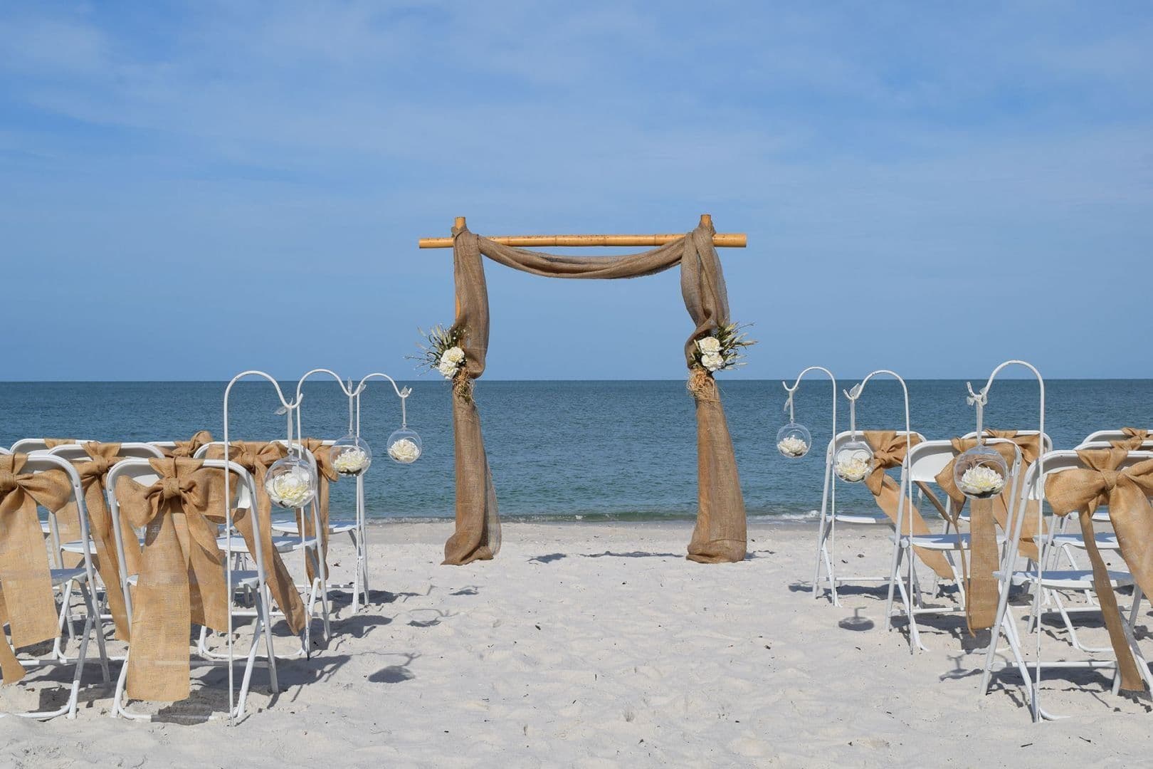 Bamboo wedding arch with white draping on a Gulf Coast beach